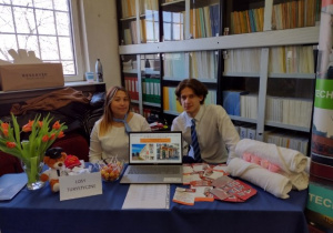 Uczniowie na stoisku przygotowanym na Festiwal zawodów, na którym znajduje się: laptop, złożone ręczniki, ulotki promujące ZSETH.